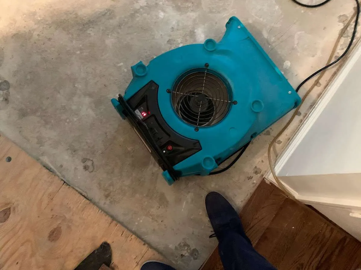 Air mover drying subfloor during Commercial Water Damage Restoration in Hales Corners